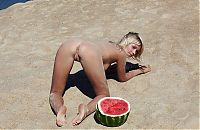 Babes: young blonde girl on the beach eating a watermelon