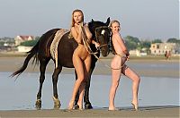Babes: two blonde girls on the beach with a horse
