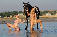 Babes: two blonde girls on the beach with a horse