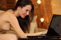 Nake.Me search results: young brunette girl with a laptop strips on the couch in the living room
