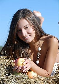 Babes: cute young brunette girl in the hay with apples