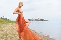 Nake.Me search results: blonde girl with textile fabric at the lake with fortress