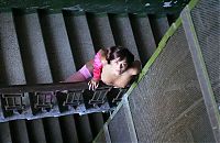 Babes: young brunette girl reveals in pink stockings and the jacket on stairs