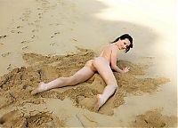 Nake.Me search results: young black haired girl in the sand on the rocky shore with the rough sea