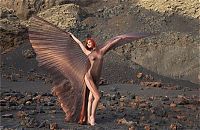 Babes: young red haired girl with butterfly wings on rocky mountains