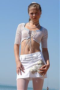 Nake.Me search results: young brunette girl reveals in white top, skirt and stockings at the sea