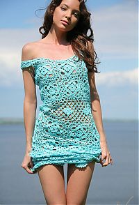 Babes: cute young curly brunette girl reveals outside in a light blue knitted dress