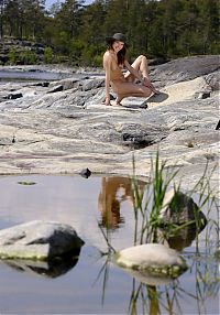 Babes: young red haired girl wearing a hat at the lake on rocks