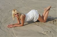 Babes: young swedish blonde girl with blue eyes reveals her white chemise in the sand