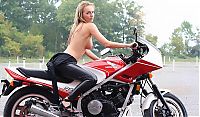 Babes: blonde girl undresses her leather overall on the honda motorcycle