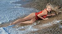 Babes: blonde girl reveals her red chemise on the beach in the sea