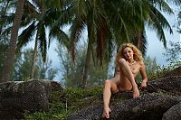 Babes: young curly reddish blonde girl strips her pink lingerie on the island with palm trees