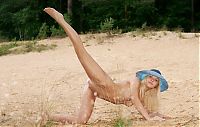 Babes: cute young blonde girl with large labia minora wearing a blue hat on the sand