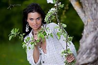 Babes: young black haired girl with blue eyes reveals on the green glade with a spring tree