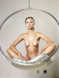 Nake.Me search results: young brunette girl posing in a transparent vitreous glass swing chair