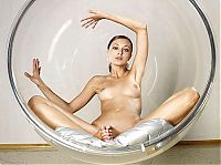 Nake.Me search results: young brunette girl posing in a transparent vitreous glass swing chair