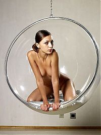 Nake.Me search results: young brunette girl posing in a transparent vitreous glass swing chair