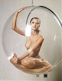 Nake.Me search results: young brunette girl posing in a transparent vitreous glass swing chair