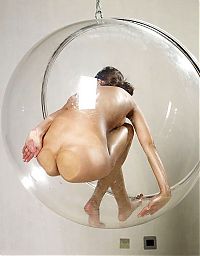 Nake.Me search results: young brunette girl posing in a transparent vitreous glass swing chair