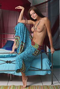 Babes: cute young brunette girl with long hair and blue eyes reveals her harem pants in the middle east style bedroom