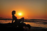 Babes: blonde girl tanned on the beach with driftwood during the sunset