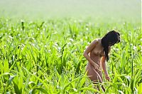 Babes: young red haired girl undresses her white sleeveless shirt on the green field outside in the nature