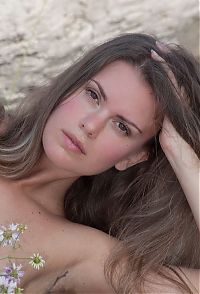 Nake.Me search results: young brunette girl with wild flowers undresses a long white skirt on the driftwood at the sea