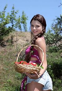 Nake.Me search results: young brunette girl with a pigtail and strawberries in the handbasket undresses her pink bra and short jeans outside on the open glade area