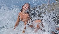 Babes: young blonde girl undresses her white blouse on the rocky shore at the sea